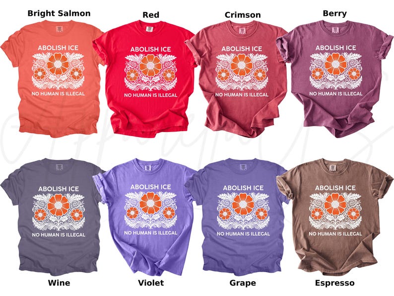 May include: A collection of eight t-shirts in various colors, including bright salmon, red, crimson, berry, wine, violet, grape, and espresso. Each shirt features the text "ABOLISH ICE" and "NO HUMAN IS ILLEGAL" with a floral design.