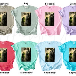 Pu&ograve; includere: Otto magliette in vari colori, tra cui Sandstone, Bay, Blossom, Orchid, Watermelon, Island Reef, Chambray e Lagoon. Ogni maglietta presenta la parola "RESIST" sopra una grafica di figure.