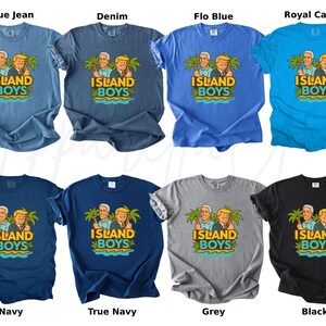Pu&ograve; includere: Una collezione di otto t-shirt in vari colori, tra cui blu, navy, grigio e nero. Ogni maglietta presenta una grafica di due uomini con palme e la scritta "ISLAND BOYS". Abbigliamento casual.