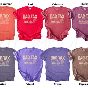 May include: A collection of eight t-shirts in various colors, including bright salmon, red, crimson, berry, wine, violet, grape, and espresso. Each shirt features the text "DAD TAX" with a graphic of food and drinks.