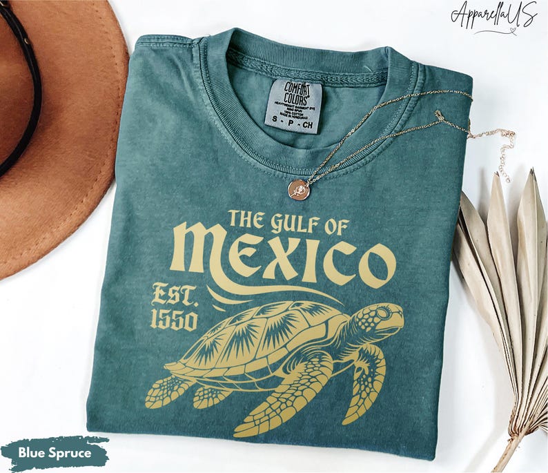 May include: A teal blue t-shirt with a vintage-style graphic of a sea turtle and the text "The Gulf of Mexico Est. 1550".