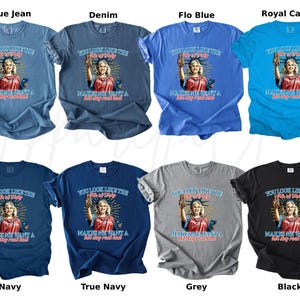 Puede incluir: Una colecci&oacute;n de camisetas en varios colores, incluyendo azul, gris y negro. Cada camiseta presenta un gr&aacute;fico de una mujer que se asemeja a la Estatua de la Libertad, con el texto "You look like the 4th of July makes me want a hot dog real bad!"