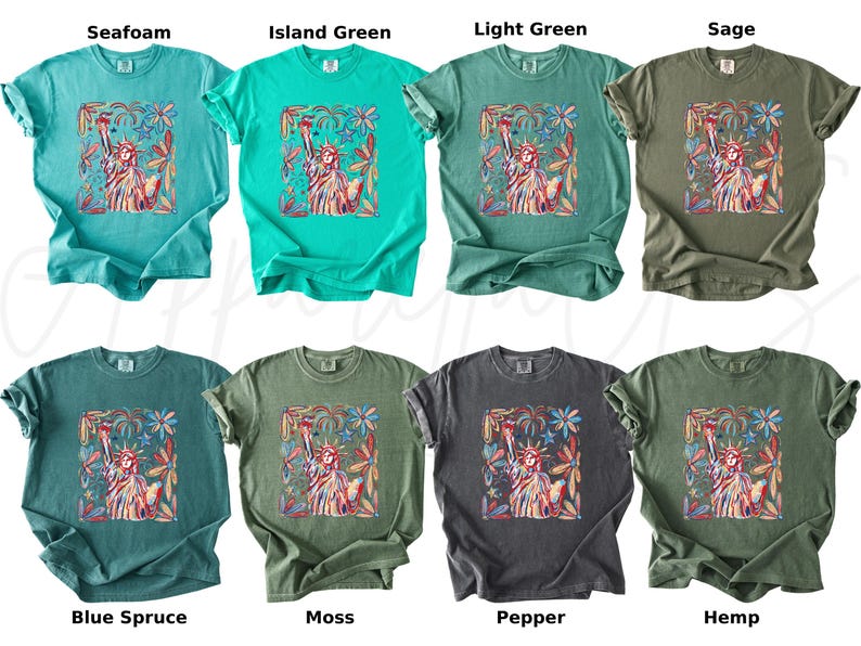 Puede incluir: Ocho camisetas en varios colores, incluyendo espuma de mar, verde isla, verde claro y salvia. Cada camiseta presenta un gr&aacute;fico de la Estatua de la Libertad rodeada de elementos florales. Los colores incluyen abeto azul, musgo, pimienta y c&aacute;&ntilde;amo.