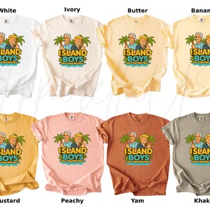 Pu&ograve; includere: Una collezione di t-shirt in vari colori, tra cui bianco, avorio, burro, banana, senape, pesca, igname e kaki. Ogni maglietta presenta la scritta "ISLAND BOYS" con un'illustrazione di due uomini sotto palme.