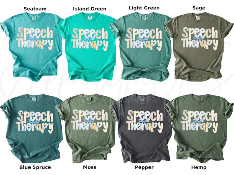 May include: A collection of eight t-shirts in various colors, including seafoam, island green, and sage. Each shirt displays the words "Speech Therapy" in a playful font with a floral design. The shirts are short-sleeved.