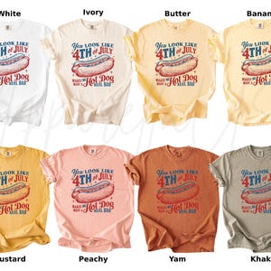 May include: A collection of eight t-shirts in various colors, including white, ivory, butter, banana, mustard, peachy, yam, and khaki. Each shirt features a graphic of a hot dog and the text "You look like 4th of July makes me want a hot dog real bad."