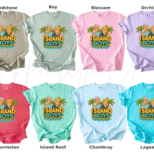 Pu&ograve; includere: Una collezione di otto t-shirt in vari colori, tra cui sabbia, baia, fiore, orchidea, anguria, barriera corallina, chambray e laguna. Ogni maglietta presenta una grafica di due uomini con palme e la scritta "ISLAND BOYS".