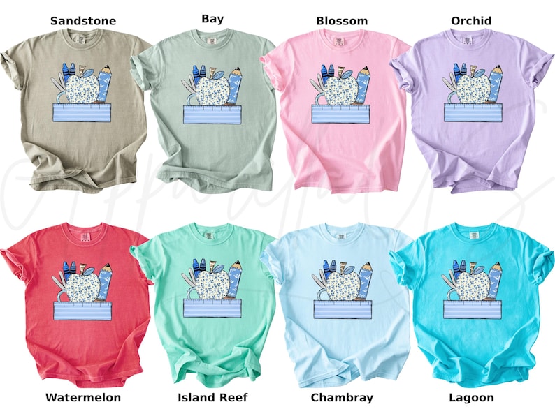 May include: Ten different color t-shirts with a graphic of a blue apple with school supplies around it and the text "First Day of School" printed on a blue banner below the apple.