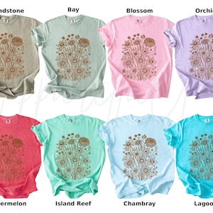 Pode incluir: Oito camisetas de manga curta em v&aacute;rias cores, incluindo Sandstone, Bay, Blossom, Orchid, Watermelon, Island Reef, Chambray e Lagoon. Cada camisa apresenta um design floral em uma cor contrastante. As camisas s&atilde;o exibidas em um fundo branco.