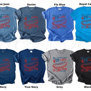 May include: A collection of eight t-shirts in various colors, including blue, navy, grey, and black. Each shirt features a red graphic of a hot dog and the text "You look like 4th of July makes me want a hot dog real bad."