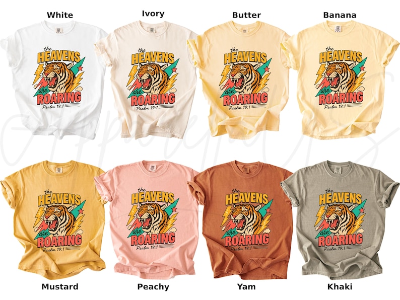 May include: A collection of t-shirts in various colors, including white, ivory, butter, banana, mustard, peachy, yam, and khaki. Each shirt features a graphic of a tiger with the text "The Heavens are Roaring" and "Psalm 19:1".