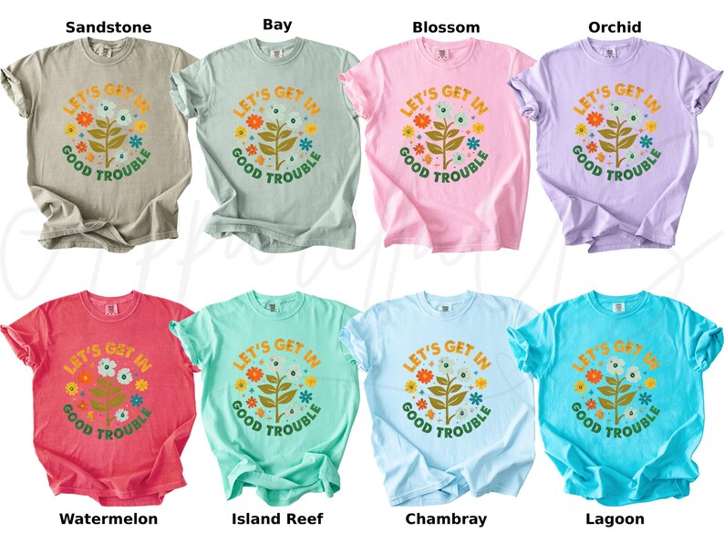 Peut inclure: Huit t-shirts de couleurs vari&eacute;es, chacun portant l'inscription "LET'S GET IN GOOD TROUBLE" dans un motif floral. Les couleurs comprennent le beige, le vert clair, le rose, le violet, le rouge, le turquoise, le bleu clair et le bleu sarcelle.