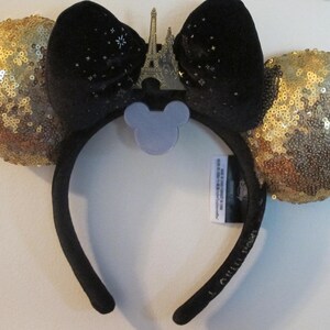 Könnte beinhalten: Schwarze Samt-Minnie-Maus-Ohren mit goldenen Glitzer-Sequin-Ohren und einem goldenen Eiffelturm-Anhänger.