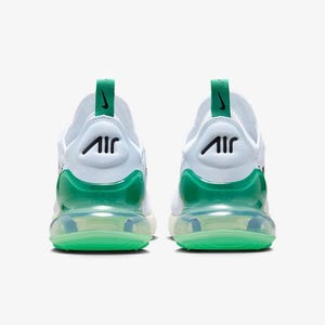 May include: Pair of white athletic shoes with green accents. The shoes feature a green heel counter and a green air bubble sole. The Nike Air logo is visible on the back of the shoe. The shoes are designed for athletic activities.
