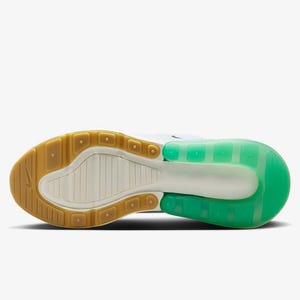May include: Bottom view of a white and green athletic shoe. The sole features a brown rubber heel and toe, with a white and green midsole. The shoe's design includes a visible air unit in the heel, and a textured pattern on the sole.