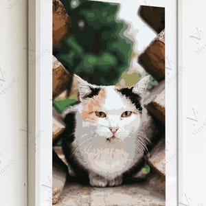 Puede incluir: Impresión enmarcada de un gato con pelaje blanco, negro y naranja. El gato mira directamente al espectador, enmarcado por una estructura de madera. El fondo muestra follaje verde. La impresión está en un marco blanco.
