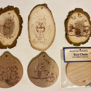 May include: Six wooden ornaments with various Christmas-themed designs, including an angel, a bird, a nativity scene, and a snowman. The ornaments are all made from natural wood and have a rustic look. The ornaments are packaged in a clear plastic bag with a price tag that reads "American Handicrafts Key Chain Fort Worth, Texas 76111 $1.69".