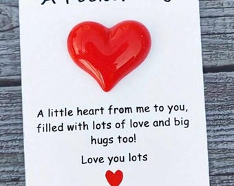 Op de afbeelding: Een "A Pocket Hug" kaart met een glanzend rood hart. De tekst luidt: "Een klein hartje van mij voor jou, gevuld met veel liefde en dikke knuffels! Ik hou van je."