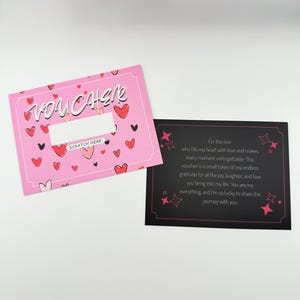 May include: A pink card with the word "VOUCHER" in white lettering and a scratch-off area. The card is decorated with red hearts. The back of the card is black with white stars and pink text that reads: "For the one who fills my heart with love and makes every moment unforgettable: This voucher is a small token of my endless gratitude for all the joy, laughter, and love you bring into my life. You are my everything, and I'm so lucky to share this journey with you."