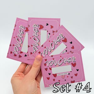 May include: Set of four pink scratch-off cards with a heart pattern and the text "You Cash" printed on each card. The cards are labeled "Set #4".