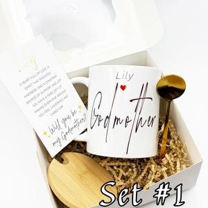 May include: A white gift box set with a mug, spoon, and coaster. The mug says "Lily Godmother" with a red heart. A card reads "Will you be my Godmother?" and "Set #1" is printed on the box.