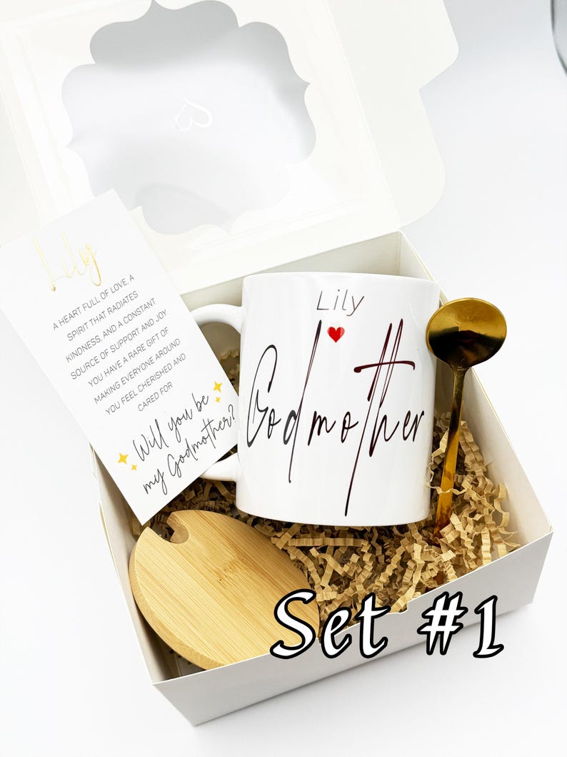 May include: A white gift box set with a mug, spoon, and coaster. The mug says "Lily Godmother" with a red heart. A card reads "Will you be my Godmother?" and "Set #1" is printed on the box.