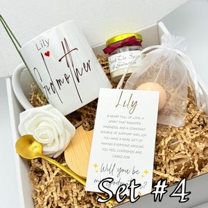 May include: A gift set in a white box, featuring a white mug with "Lily Godmother" in script, a small candle, a bath bomb, a gold spoon, a wooden coaster, and a card that says "Will you be my Godmother?" Set #4.