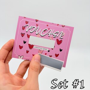 May include: Pink scratch-off voucher with a heart pattern and the word "VOUCHER" in white lettering. The voucher has a silver scratch-off area with the text "SCRATCH HERE" in black. Set #1 is written in black below the voucher.