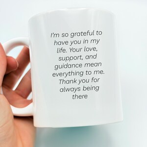 May include: White ceramic mug with a curved handle. The mug features black text that reads: "I'm so grateful to have you in my life. Your love, support, and guidance mean everything to me. Thank you for always being there."