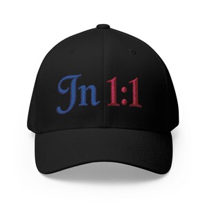 May include: Black baseball cap with the embroidered text "Jn 1:1" in blue and red. The cap has a curved brim and a structured fit, suitable for casual wear.
