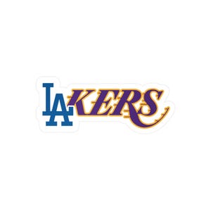 May include: A sticker featuring the Los Angeles Lakers logo. The logo includes the letters "LA" in blue, and the word "LAKERS" in purple with a gold outline. The sticker is white with a glossy finish.