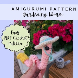 May include: A crochet amigurumi worm with a pink body, a yellow tail, and a white sun hat with a light blue trim. The worm has black eyes and a light blue chin strap. Text reads: AMIGURUMI PATTERN Gardening Worm and Easy PDF Crochet Pattern.