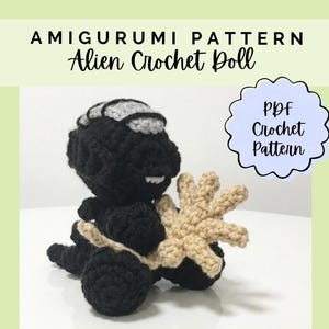 May include: A black crocheted alien doll with a grey head accent, holding a beige star-shaped object. The text reads AMIGURUMI PATTERN Alien Crochet Doll and PDF Crochet Pattern. The doll features a textured yarn construction and small white teeth.