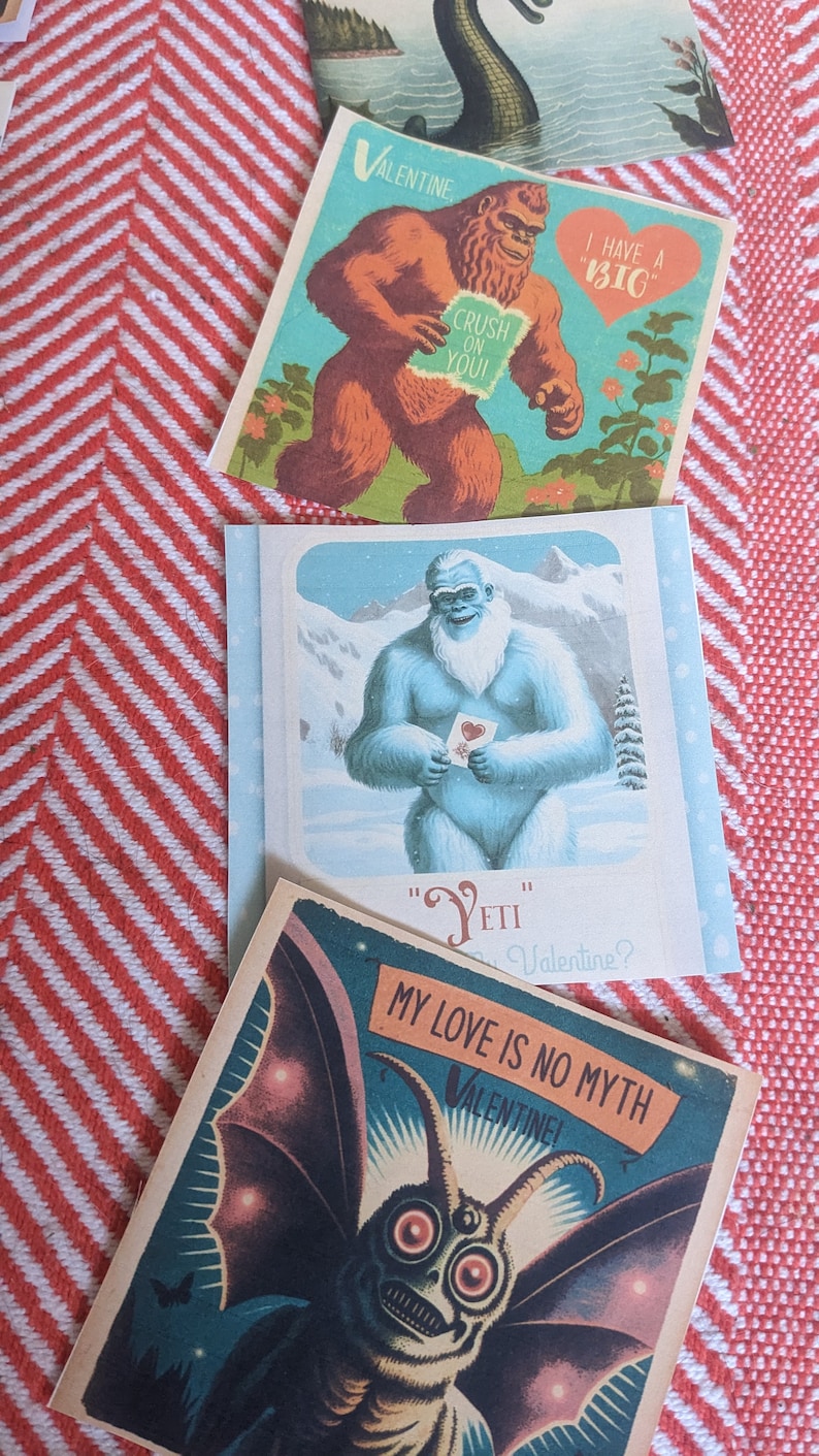 May include: Three Valentine's Day cards featuring illustrations of a Bigfoot, Yeti, and a Mothman. The Bigfoot card says "I have a "BIG" crush on you!" The Yeti card says "Yeti be my Valentine?" The Mothman card says "My love is no myth Valentine!"