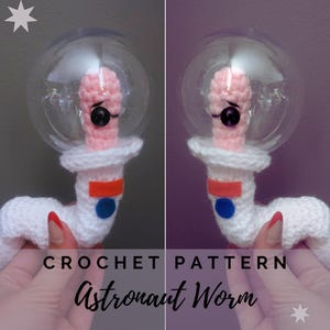May include: A crocheted astronaut worm toy. The worm is white with a pink head inside a clear bubble helmet. It has a black eye and is wearing a white spacesuit with red and blue accents. The text "CROCHET PATTERN Astronaut Worm" is below.