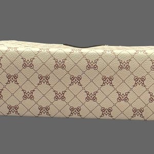 May include: A rectangular, cream-colored wallet with a repeating pattern of brown decorative elements. The wallet has a gold-colored zipper and a black interior. The pattern is a repeating design of the letter "M".