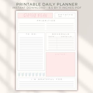 May include: Printable daily planner with a soft pink and white design. The planner includes sections for daily plans, priorities, to-do lists, schedules, notes, and gratitude. The text "DAILY PLAN" is in a handwritten style.