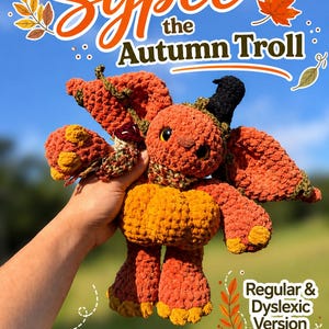May include: A crocheted orange and yellow troll plush toy with large ears, a small black hat, and a pumpkin-shaped body. The text Sypce the Autumn Troll and Regular & Dyslexic Version Available is displayed in white and orange against a blue sky.