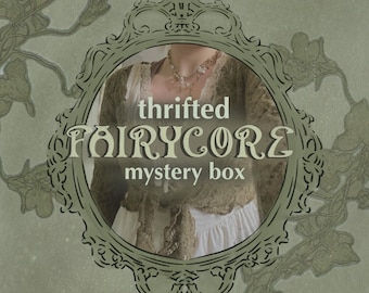 Puede incluir: Un anuncio de caja misteriosa con un cárdigan marrón con cordones sobre una prenda blanca y un collar de varias capas. El texto "thrifted FAIRYCORE mystery box" aparece dentro de un marco ovalado verde oscuro sobre fondo verde claro.