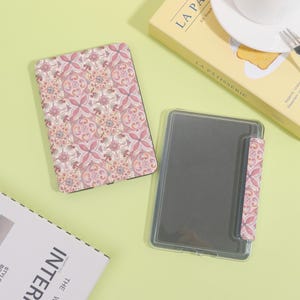 K&ouml;nnte beinhalten: Eine offene und eine geschlossene E-Reader-H&uuml;lle mit einem rosa-wei&szlig;en Blumenmuster. Die offene H&uuml;lle ist transparent mit einem schwarzen Bildschirm. Die geschlossene H&uuml;lle hat ein passendes Blumenmuster. Der Hintergrund ist hellgr&uuml;n.