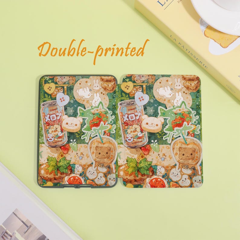 May include: Two decorative phone cases with a whimsical design. Each case features a repeating pattern of cartoon bears, bunnies, strawberries, and soda cans. The text "Double-printed" is in orange script above the cases.