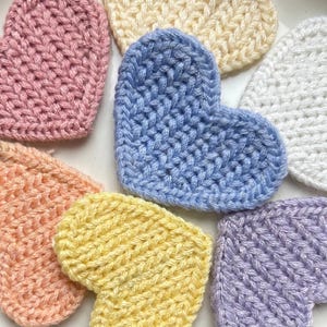 Enfeites de coração em lã tricotada, disponíveis em pacotes de 1, 5 ou 10 unidades. Diversas cores à sua escolha. Ideais para tricô, costura e scrapbooking.