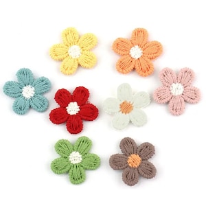 May include: Seven embroidered flower appliques in assorted colours. Each flower has a five-petal design with a contrasting centre. Colours include yellow, orange, pink, red, white, blue, green, and brown. These appliques are suitable for craft projects.