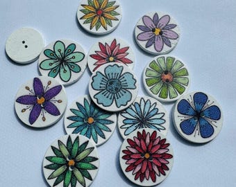 May include: A collection of wooden buttons with floral designs in various colors, including blue, green, purple, and red. The buttons are round and have a two-hole design. One button is plain with two holes.