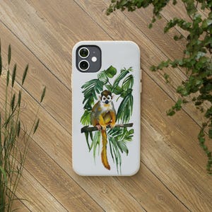 May include: A white phone case featuring a watercolor illustration of a squirrel monkey perched on a branch with green leaves. The monkey has yellow, brown, and white fur. The case has a dual-lens camera cutout.