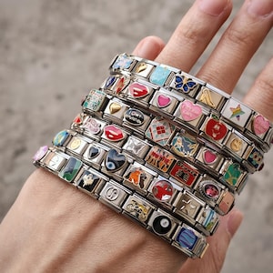 a person's hand holding a stack of bracelets