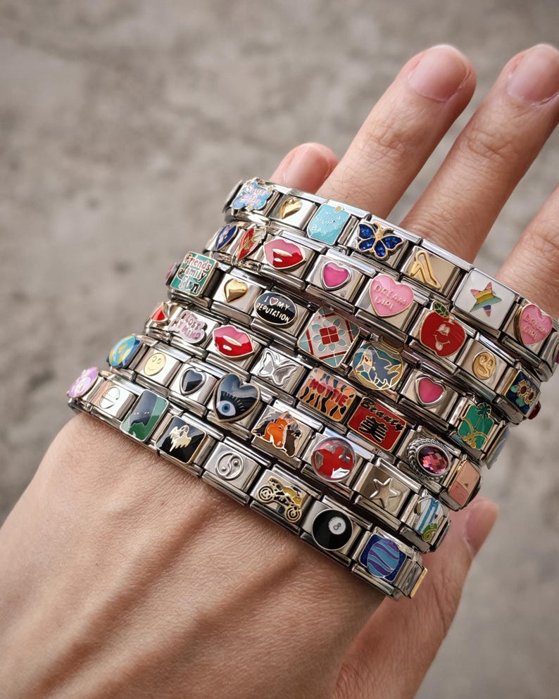 a person's hand holding a stack of bracelets