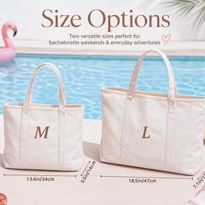 May include: Two off-white canvas tote bags with brown embroidered letters M and L. The medium bag measures 13.4 inches wide, 11.4 inches high, and 5.5 inches deep. The large bag measures 18.5 inches wide, 13.4 inches high, and 7.1 inches deep.