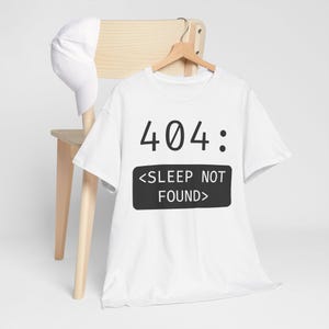 May include: White t-shirt with a black graphic that says "404: <SLEEP NOT FOUND>"