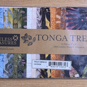 May include: A pack of 42 pieces of 5 inch by 5 inch fabric squares labeled Timeless Treasures Tonga Treats Hayride. The collection features various batik patterns in shades of blue, green, yellow, orange, brown, and black, all wrapped in clear plastic.